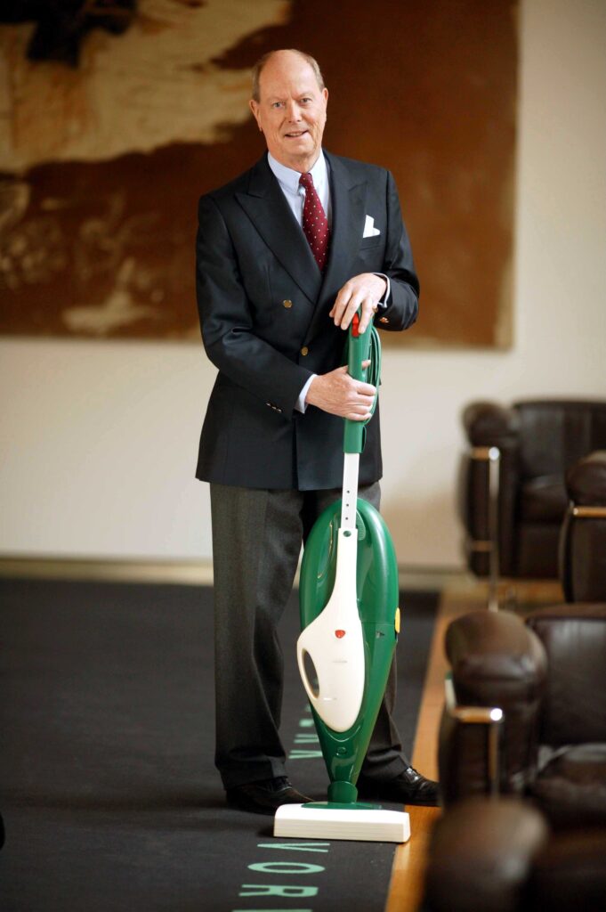 Jörg Mittelsten Scheid, Vorstand von Vorwerk, mit einem Kobold-Staubsauger in der Hand