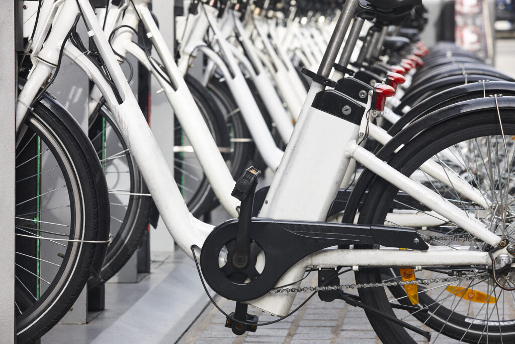 Viele weiße Elektrofahrräder stehen hintereinander 