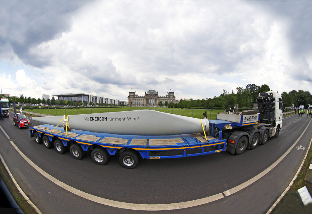 LKW mit Enercon Windkraftglügel in einer Kurve auf einer Straße