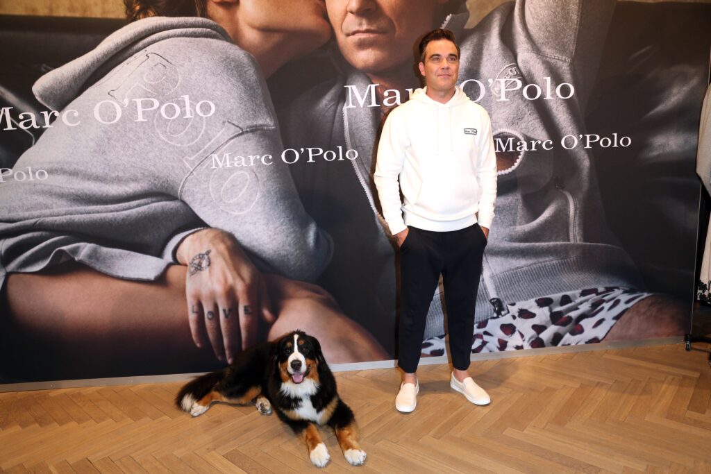 Marc O`Polo Robbie Williams vor dem Mark O`Polo Logo