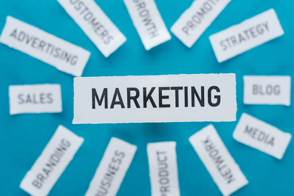 blauer Hintergrund mit Marketing in der Mitte. viele unscharfe Zettel mit Sales, Advertising, Branding etc.