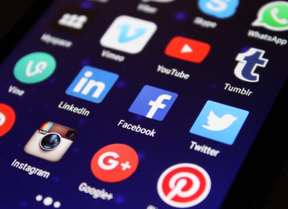 Ein Smartphone mit verschwommenem Social-Media-Feed liegt auf einem Schreibtisch als Symbolbild zur Facebook-Whistleblowerin – Foto: Pixelkult / Pixabay