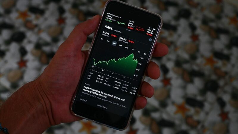 Ein Smartphone mit Börsenkursen auf dem Display liegt neben einem Laptop und symbolisiert das Trade Republic Ranking im Neobroker-Vergleich – Foto: sergeitokmakov / Pixabay
